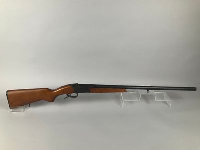 a rifle with a wooden barrel on a clear stand