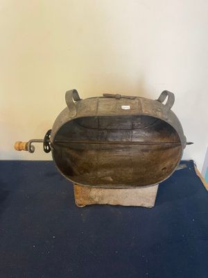 une grande casserole en métal posée sur un tapis bleu