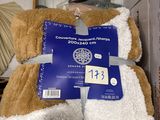 a brown teddy bear that is wrapped in a blanket