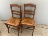 two wooden chairs sitting next to each other on the floor