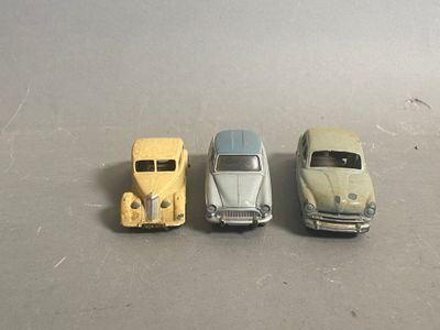 three toy cars sitting next to each other on a table