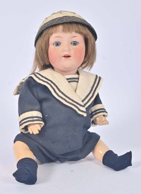 a doll that is sitting on the ground wearing a hat