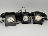 trois téléphones à l'ancienne sont alignés sur une surface blanche