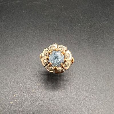 Gros plan sur une bague en or ornée d'une topaze bleue
