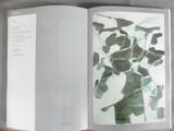 someone is holding a book with a picture of a plant in it