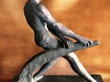 a statue of a man sitting on top of a bench