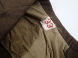 a close up of a brown jacket with a red number on it
