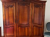 a large wooden armoire in the corner of a room