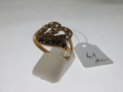 an image of a gold ring with a black diamond on it