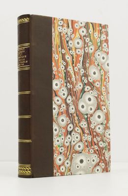 un vieux livre à la couverture marron, ornée d'un motif de crânes