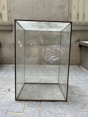 une boîte en verre posée par terre devant un immeuble