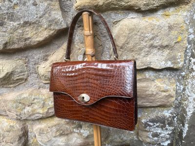 un sac à main marron accroché à un poteau en bois