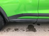a green car that is parked on the side of the road