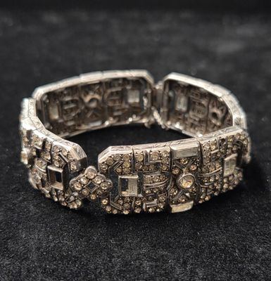 gros plan d'un bracelet en argent sur une surface noire