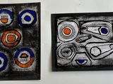 two paintings on the wall one is black and the other is blue and orange