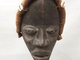 une image représentant une tête en bois coiffée d'un chapeau
