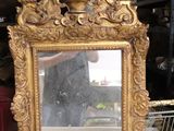 un cadre doré avec un miroir posé sur une table