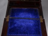 a small wooden box with a blue velvet inside