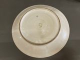 a white plate with a gold rim sitting on a table