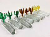 several small glass cactus figurines are lined up in a row