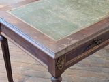 a small table with a green top on a wooden floor