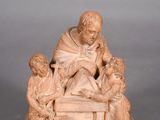 a statue of a man and two children sitting on a bench