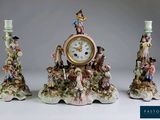 trois figurines surmontées d'une horloge