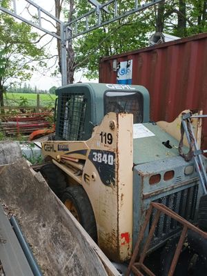 un tracteur garé à côté d'un tas de bois