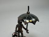 a figurine of a man holding an umbrella and a suitcase