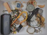 a white box filled with assorted items including a knife, watch and other items