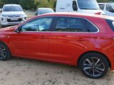a red car parked in a lot with other cars