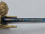 a blue pen with a gold flower on top of it