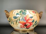 un vase orné de fleurs peintes, posé sur une table