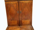 an old wooden cabinet with two doors and a drawer on top of it