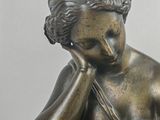 a bronze statue of a woman reading a book