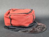un chapeau rouge orné d'un ruban noir sur le dessus