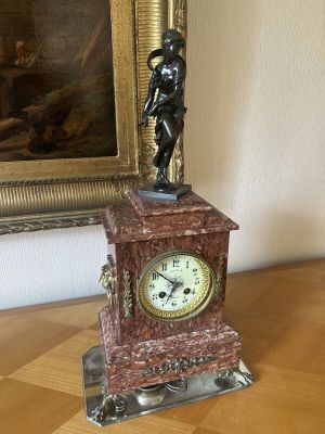 a statue of a man holding a clock on top of a table