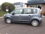 a small grey car parked in front of a building