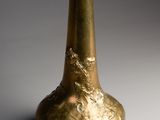 a gold vase that is sitting on a table