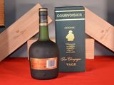 a bottle of courvoisier next to a box of wine