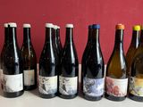 six bouteilles de vin sont alignées sur une table