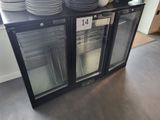 une porte vitrée surmontée de plaques dans un magasin