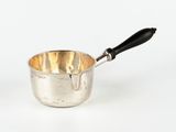 une tasse argentée avec une anse noire sur un fond blanc