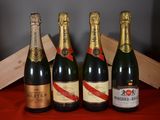 quatre bouteilles de champagne sont alignées sur une table