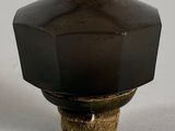 a black knob on a white table with a white background