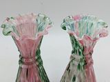 pair of pink and green vases sitting on top of a white surface