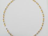a gold and silver necklace on a white surface