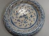 a blue and white plate with a flower design on it