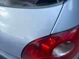 a cat sitting on the back of a car in the parking lot
