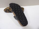 pair of black sandals on a white surface with a white background